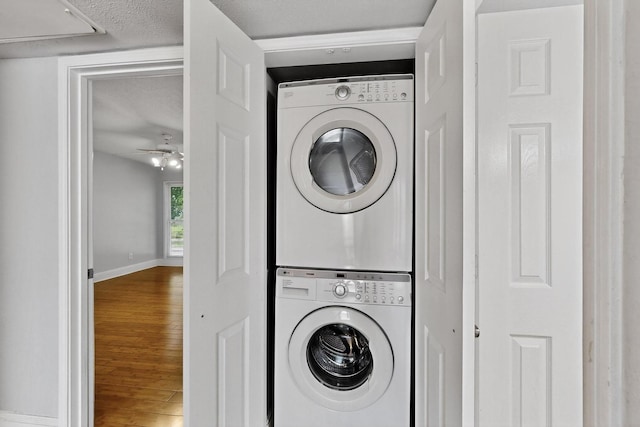 7736 Meadow Rd Unit 203, Dallas, TX 75230 - washroom with stacked washing machine and dryer, wood finished floors, a textured ceiling, and a ceiling fan