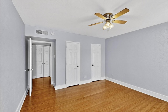 7736 Meadow Rd Unit 203, Dallas, TX 75230 - unfurnished bedroom with light wood-type flooring, ceiling fan, and multiple closets