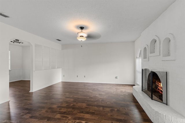809 Monique, Cedar Hill, TX 75104 - unfurnished living room featuring hardwood / wood-style floors, a fireplace, a textured ceiling, ceiling fan, and baseboards