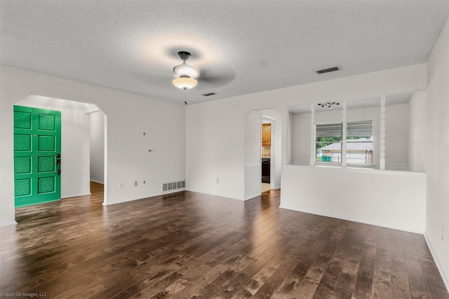 809 Monique, Cedar Hill, TX 75104 - unfurnished living room with arched walkways, hardwood / wood-style floors, a ceiling fan, and a textured ceiling