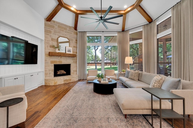 4340 Powers Branch Dr, Midlothian, TX 76065 - living room featuring a stone fireplace, ceiling fan, beamed ceiling, wood finished floors, and high vaulted ceiling