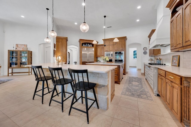4340 Powers Branch Dr, Midlothian, TX 76065 - kitchen featuring built in appliances, arched walkways, open shelves, custom exhaust hood, and a breakfast bar area