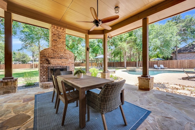 4340 Powers Branch Dr, Midlothian, TX 76065 - fenced backyard with an outdoor brick fireplace, a patio area, a ceiling fan, a pool with connected hot tub, and outdoor dining area