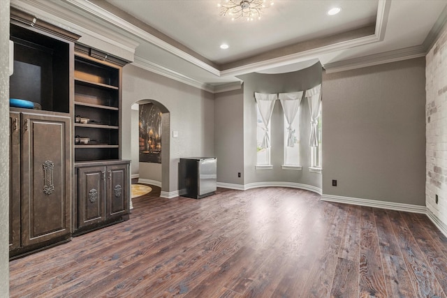 1608 Rivercrest Ct, Fort Worth, TX 76107 - unfurnished living room featuring arched walkways, dark wood-style flooring, ornamental molding, baseboards, and a tray ceiling