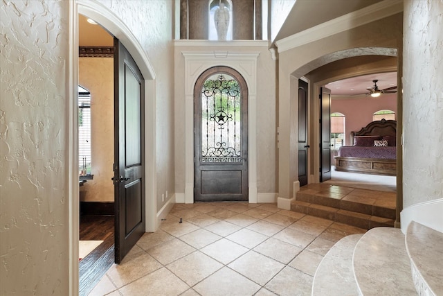 1608 Rivercrest Ct, Fort Worth, TX 76107 - entrance foyer with arched walkways, a textured wall, plenty of natural light, light tile patterned flooring, and a ceiling fan