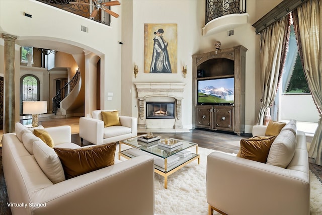 1608 Rivercrest Ct, Fort Worth, TX 76107 - living area featuring a towering ceiling, arched walkways, wood finished floors, ornate columns, and a high end fireplace