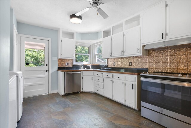 3819 Hubby Ave, Waco, TX 76710 - kitchen with appliances with stainless steel finishes, under cabinet range hood, independent washer and dryer, dark countertops, and backsplash