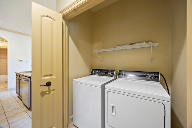 1891 Signal Ridge Pl, Rockwall, TX 75032 - washroom featuring washer and clothes dryer, arched walkways, light tile patterned floors, and baseboards