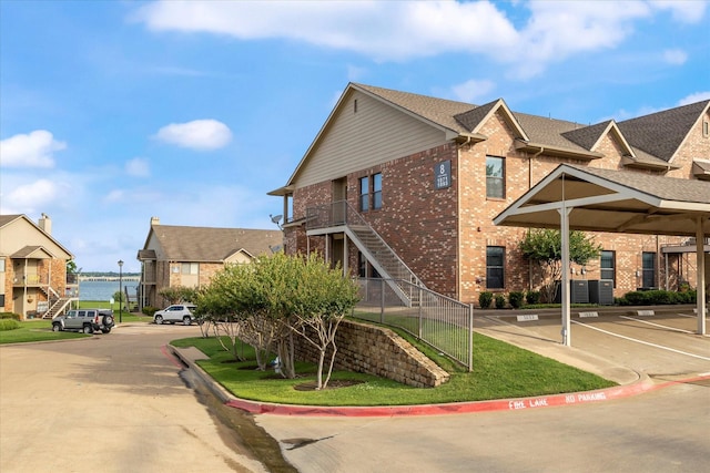 1891 Signal Ridge Pl, Rockwall, TX 75032 - view of side of property with brick siding, uncovered parking, a residential view, and stairway