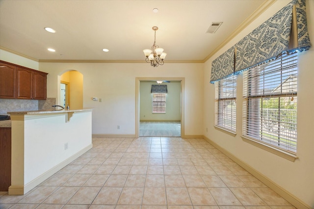 1891 Signal Ridge Pl, Rockwall, TX 75032 - kitchen with arched walkways, crown molding, plenty of natural light, a chandelier, and decorative backsplash