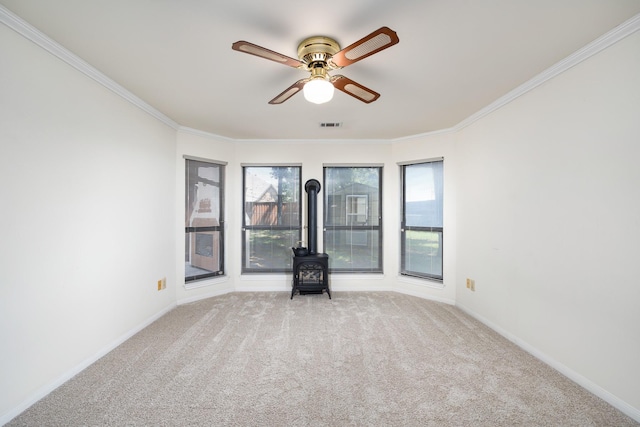 2126 Los Robles St, Grapevine, TX 76051 - carpeted spare room featuring a wood stove, a ceiling fan, crown molding, and baseboards