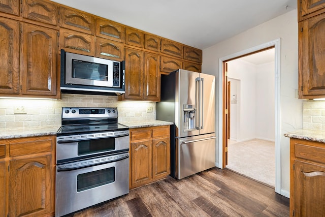 2126 Los Robles St, Grapevine, TX 76051 - kitchen with stainless steel appliances, dark wood-style floors, decorative backsplash, and brown cabinets