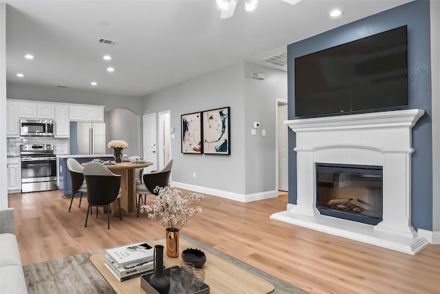 10833 Hawks Landing Rd, Fort Worth, TX 76052 - living room with baseboards, arched walkways, light wood finished floors, recessed lighting, and ceiling fan