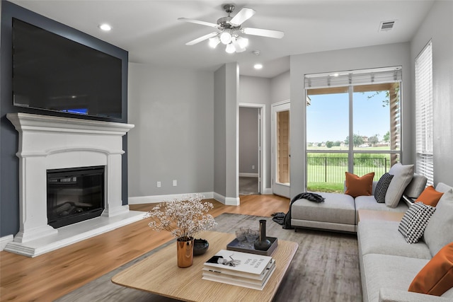 10833 Hawks Landing Rd, Fort Worth, TX 76052 - living room featuring wood finished floors, a ceiling fan, baseboards, recessed lighting, and a glass covered fireplace