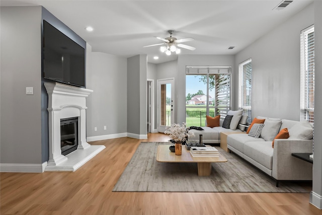 10833 Hawks Landing Rd, Fort Worth, TX 76052 - living room featuring wood finished floors, baseboards, recessed lighting, a glass covered fireplace, and a ceiling fan