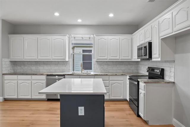 10833 Hawks Landing Rd, Fort Worth, TX 76052 - kitchen featuring appliances with stainless steel finishes, a sink, white cabinets, recessed lighting, and light wood-style flooring