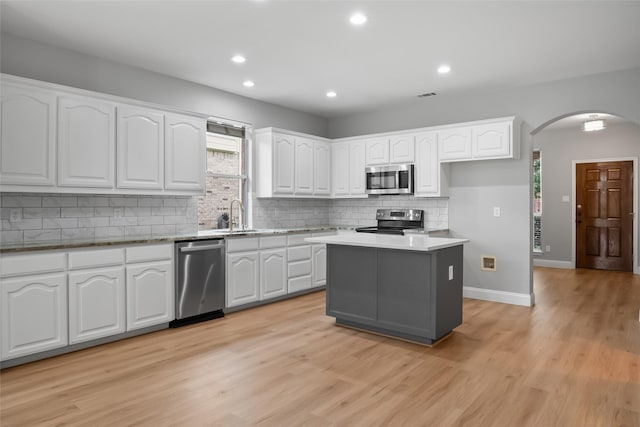 10833 Hawks Landing Rd, Fort Worth, TX 76052 - kitchen with appliances with stainless steel finishes, arched walkways, white cabinetry, decorative backsplash, and recessed lighting