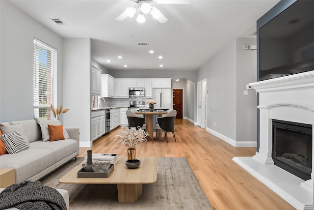 10833 Hawks Landing Rd, Fort Worth, TX 76052 - living area with ceiling fan, arched walkways, baseboards, light wood-style flooring, and recessed lighting
