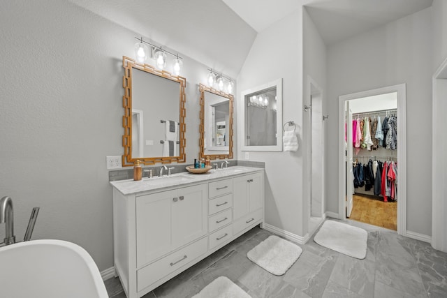 232 Skystone Dr, Irving, TX 75038 - bathroom featuring double vanity, marble look tiles, a spacious closet, a stall shower, and a freestanding tub