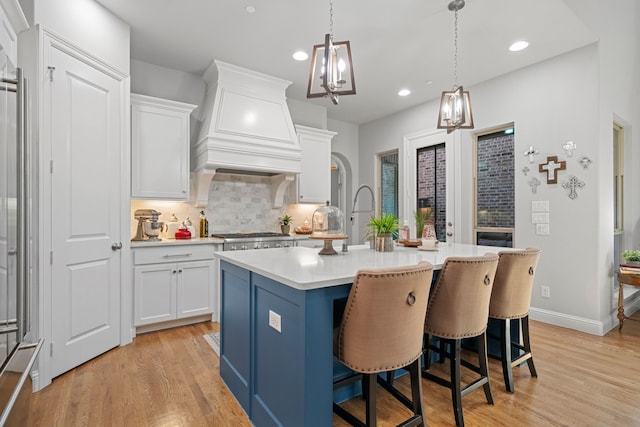 232 Skystone Dr, Irving, TX 75038 - kitchen with custom exhaust hood, light countertops, light wood-style floors, tasteful backsplash, and recessed lighting