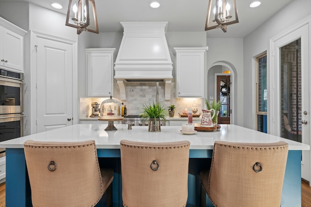 232 Skystone Dr, Irving, TX 75038 - kitchen featuring premium range hood, a center island with sink, decorative backsplash, light countertops, and recessed lighting