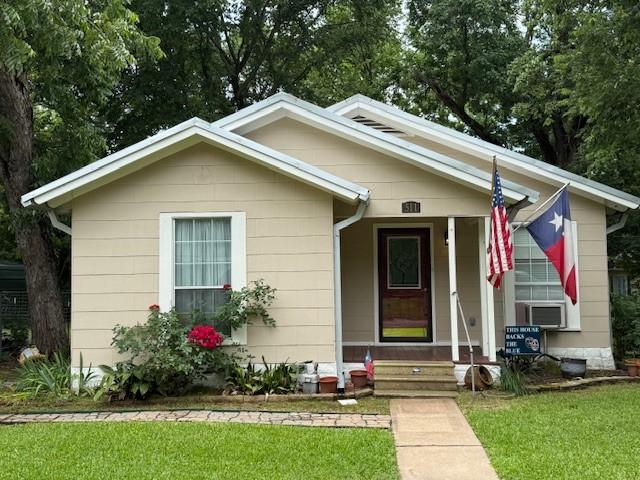 511 W Bonham Ave, Cooper, TX 75432 - bungalow with a front yard, cooling unit, and a porch