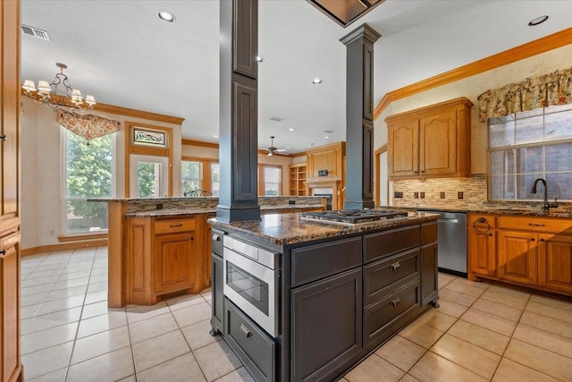 3633 Cliff View Loop, Weatherford, TX 76087 - kitchen featuring appliances with stainless steel finishes, ornate columns, a kitchen island, a sink, and decorative backsplash