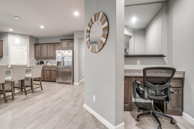 817 Nicole Way, Fort Worth, TX 76028 - kitchen featuring stainless steel fridge with ice dispenser, a breakfast bar, light wood-style floors, baseboards, and an office area