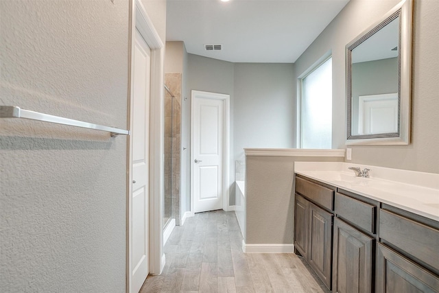817 Nicole Way, Fort Worth, TX 76028 - full bath featuring wood finished floors, a shower stall, vanity, a garden tub, and a textured wall