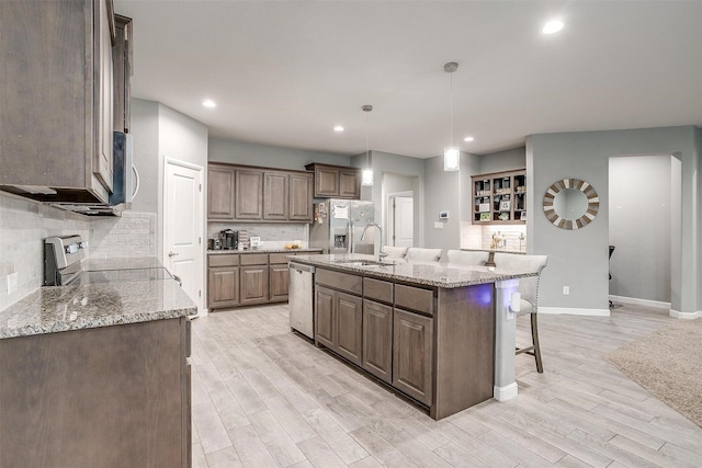 817 Nicole Way, Fort Worth, TX 76028 - kitchen with stainless steel appliances, tasteful backsplash, a breakfast bar area, a sink, and baseboards