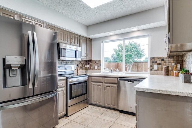4000 Via Plata, Mesquite, TX 75150 - kitchen featuring stainless steel appliances, a sink, decorative backsplash, light tile patterned floors, and a textured ceiling