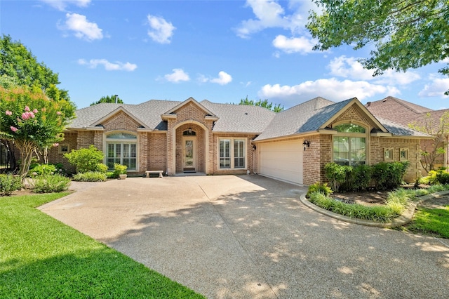 2004 Kodiak Ct, Arlington, TX 76013 - view of front of property featuring brick siding, an attached garage, concrete driveway, and a shingled roof