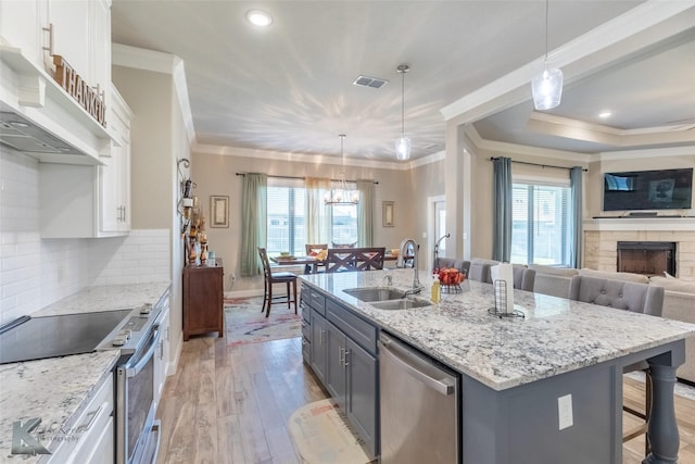 357 Blue Lake Dr, Abilene, TX 79602 - kitchen featuring appliances with stainless steel finishes, a sink, white cabinetry, light wood-style flooring, and plenty of natural light
