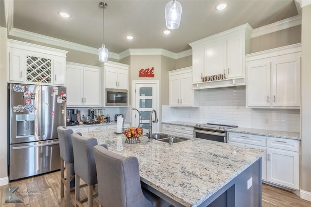 357 Blue Lake Dr, Abilene, TX 79602 - kitchen with appliances with stainless steel finishes, a sink, white cabinets, wood finished floors, and a breakfast bar area