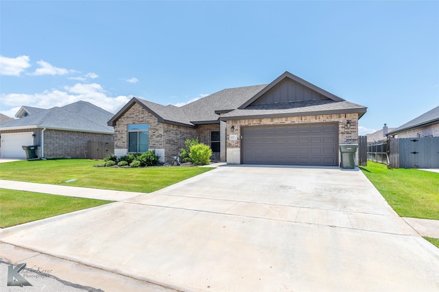 357 Blue Lake Dr, Abilene, TX 79602 - view of front facade with brick siding, a garage, concrete driveway, board and batten siding, and a shingled roof