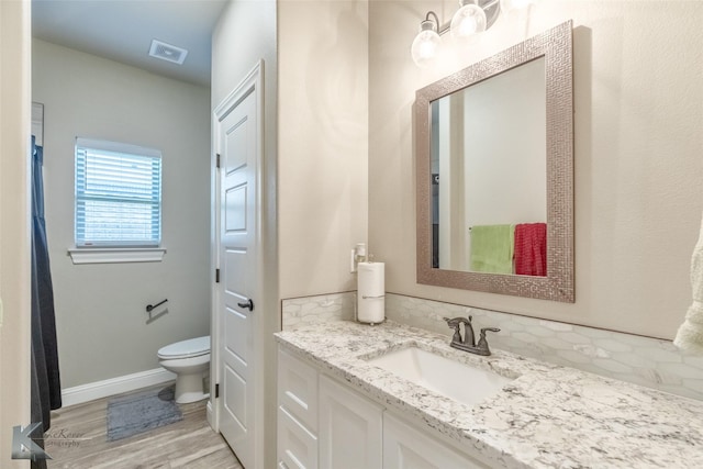 357 Blue Lake Dr, Abilene, TX 79602 - bathroom featuring vanity, toilet, wood finished floors, and baseboards