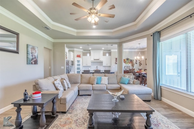 357 Blue Lake Dr, Abilene, TX 79602 - living area with light wood-style floors, a raised ceiling, ceiling fan, a chandelier, and crown molding