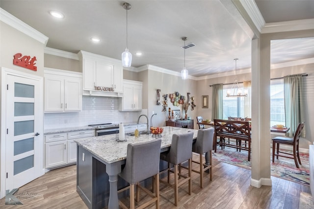 357 Blue Lake Dr, Abilene, TX 79602 - kitchen featuring stainless steel electric stove, light wood-type flooring, decorative backsplash, a kitchen island with sink, and recessed lighting