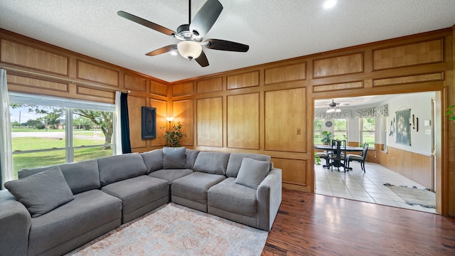 5691 Priscilla Ln, Kaufman, TX 75142 - living area with a ceiling fan, a decorative wall, a textured ceiling, wood finished floors, and wood walls