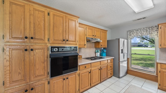5691 Priscilla Ln, Kaufman, TX 75142 - kitchen with oven, stainless steel fridge with ice dispenser, under cabinet range hood, stovetop, and light countertops
