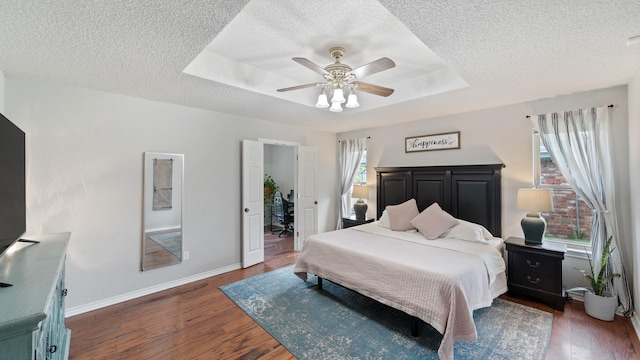 5691 Priscilla Ln, Kaufman, TX 75142 - bedroom with a textured ceiling, wood finished floors, a raised ceiling, baseboards, and ceiling fan