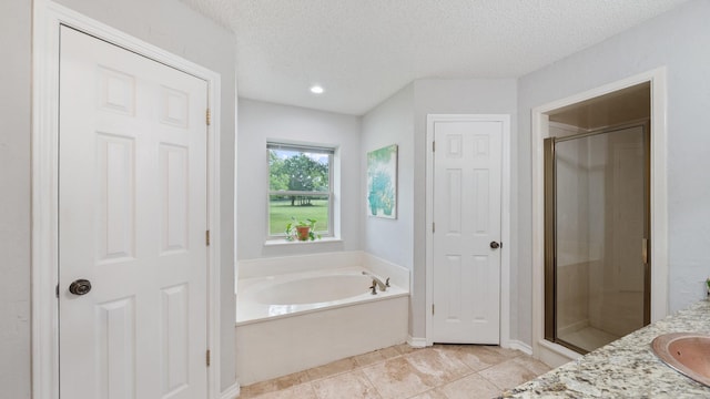5691 Priscilla Ln, Kaufman, TX 75142 - full bathroom with a shower stall, a bath, a textured ceiling, vanity, and tile patterned flooring
