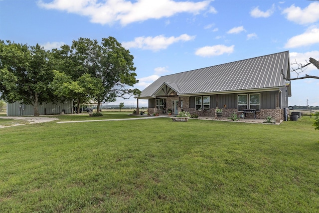 243 Fm 203, Walnut Springs, TX 76690 - view of front of home with board and batten siding, a front yard, metal roof, and central AC