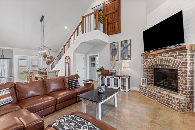 243 Fm 203, Walnut Springs, TX 76690 - living room featuring concrete floors, high vaulted ceiling, a chandelier, stairway, and a fireplace