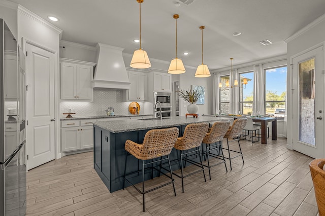 381 Oak Meadow Ln, Weatherford, TX 76085 - kitchen with custom range hood, ornamental molding, light wood-type flooring, decorative backsplash, and recessed lighting