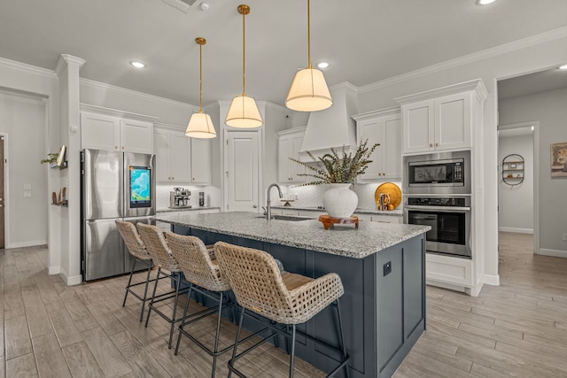 381 Oak Meadow Ln, Weatherford, TX 76085 - kitchen with stainless steel appliances, a sink, white cabinets, ornamental molding, and light wood-style floors