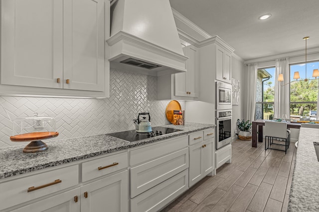 381 Oak Meadow Ln, Weatherford, TX 76085 - kitchen featuring appliances with stainless steel finishes, custom range hood, crown molding, white cabinets, and decorative backsplash
