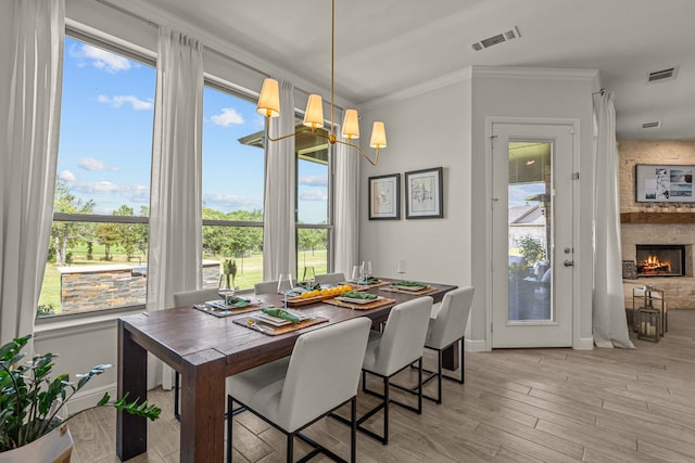 381 Oak Meadow Ln, Weatherford, TX 76085 - dining room featuring a chandelier, light wood-style floors, crown molding, baseboards, and a fireplace