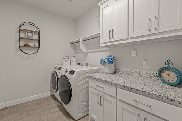 381 Oak Meadow Ln, Weatherford, TX 76085 - laundry area with washing machine and dryer, cabinet space, light wood finished floors, and baseboards