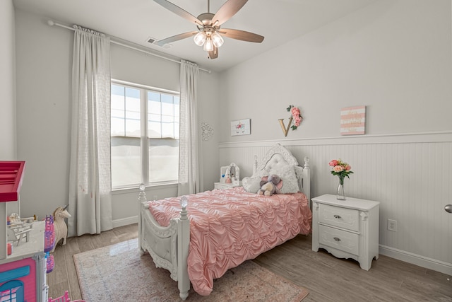 381 Oak Meadow Ln, Weatherford, TX 76085 - bedroom featuring a wainscoted wall, light wood-type flooring, and ceiling fan